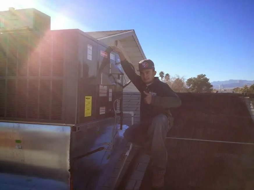 HVAC technician performing Heat Pump Repair on a rooftop unit in Lawrence